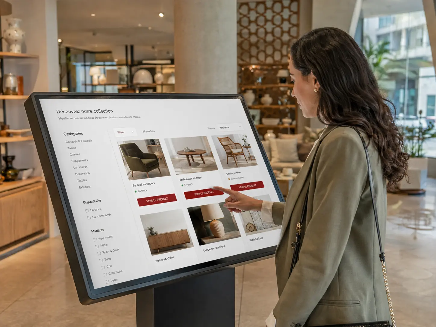 Cliente consultant un catalogue produit sur une borne interactive dans un showroom au Maroc